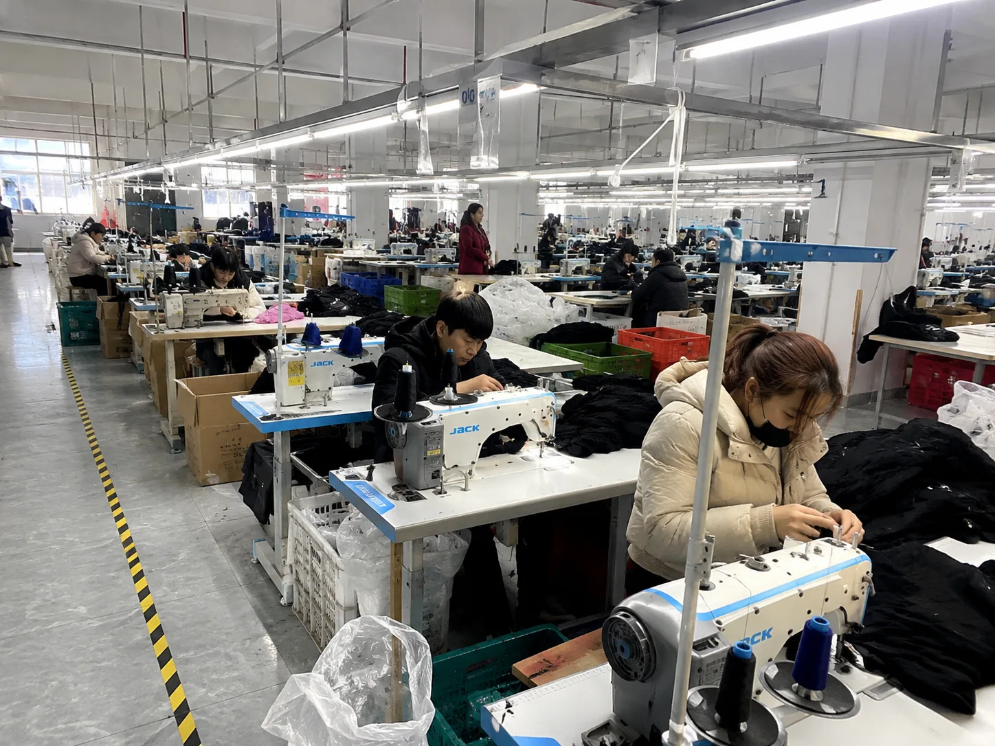 Illustrative garment factory production floor with sewing workstations in China